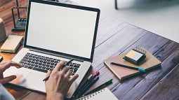 Hands typing on laptop stock image