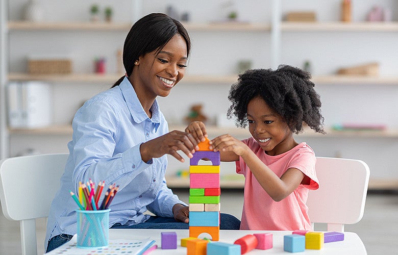 Child and teacher building blocks