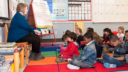 A teacher addresses a group of elementary students