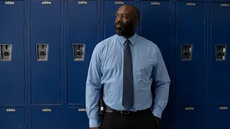 A man stands in front of school lockers