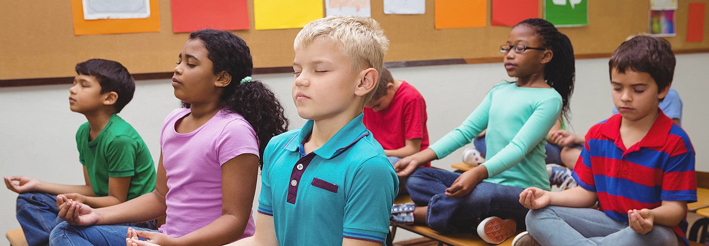 Pupils meditating on classroom desks