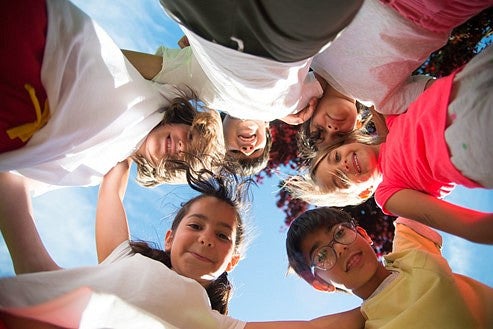 Circle of children looking down at the camera 