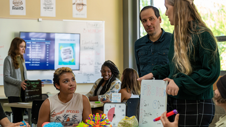 A teacher watches a student teacher teach