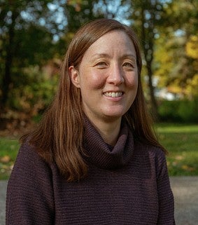 a woman smiles for an outdoor portrait