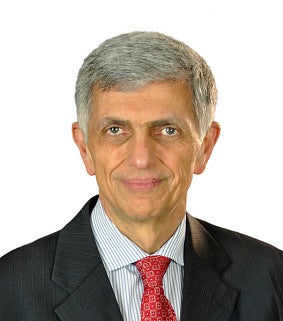 Headshot of Fariborz Pakseresht, wearing a black suit with a red tie and striped shirt