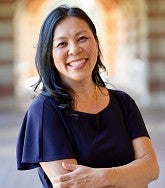 a woman smiles for a portrait under an archway