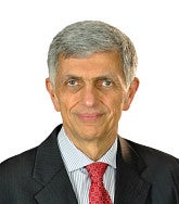 Headshot of Fariborz Pakseresht, wearing a black suit with a red tie and striped shirt